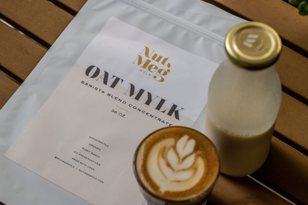 Oat milk and bottle on table with writing