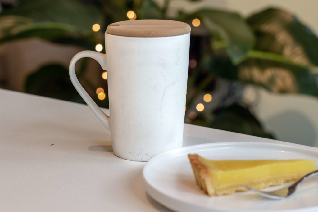 White mug on table with lemon pie