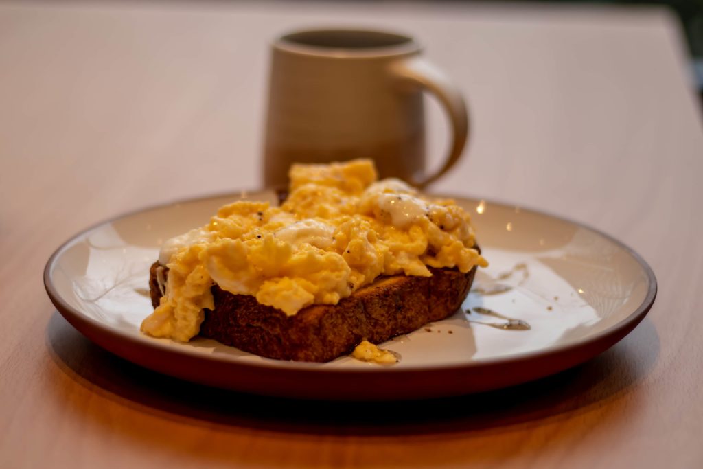 Scrambled eggs on toast with a cup in the list of the Top 10 Best Coffee Shops for Brunch in Vancouver 2019