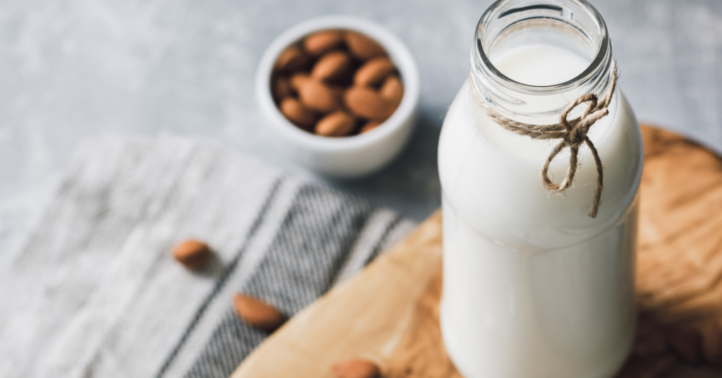 Almond milk with almonds on table